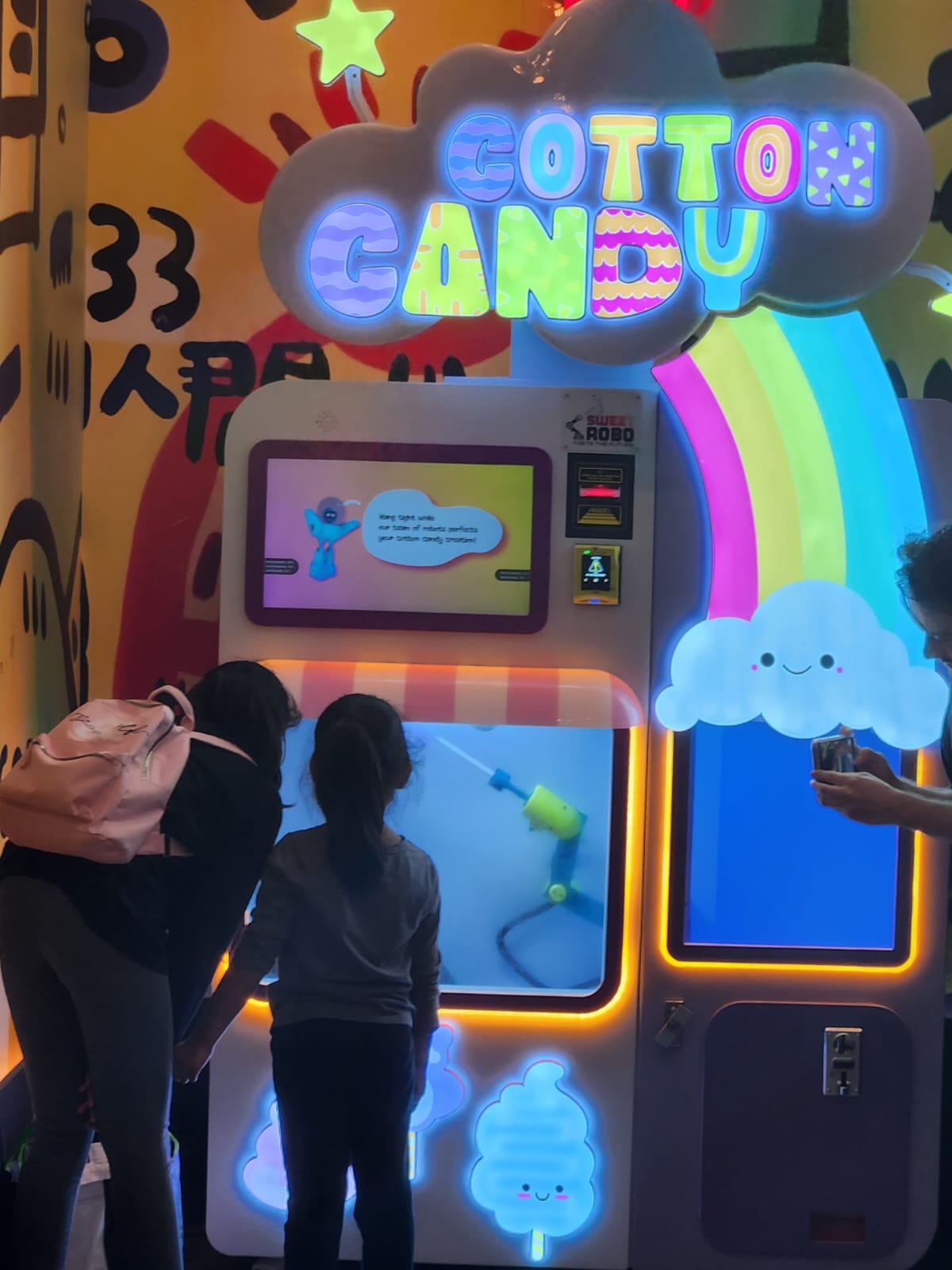 Kids enjoying cotton candy machine in venue